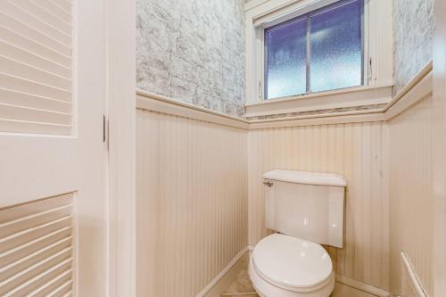 a bathroom with a white toilet and a window at A1 at Castle Hill - Townhome in Cavendish