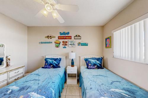 a bedroom with two beds and a ceiling fan at Pelican Inlet E133 in St. Augustine