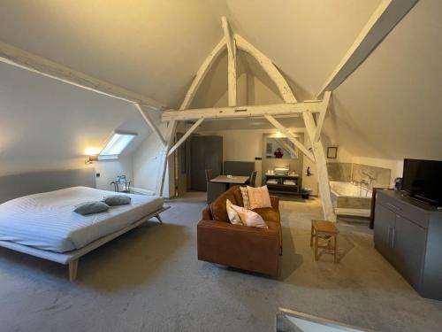 ein Schlafzimmer mit einem Bett und einem Sofa in einem Zimmer in der Unterkunft De Verborgen Parel in Borgloon