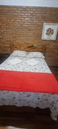 uma cama num quarto com uma parede de tijolos em COYOTE POUSADA&HOSTEL em Foz do Iguaçu