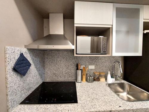 a kitchen with a sink and a microwave at Beach Haven 1BDR Condo Paseo Playa Coral - 305 in Punta Cana