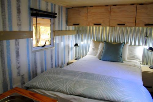 KlipdriftにあるNdlovu Tiny Home Dinokengのベッドルーム(ベッド1台、窓付)