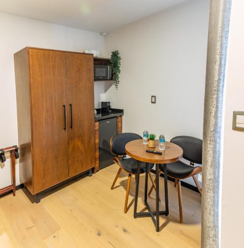 a room with a table and chairs and a cabinet at Casa Castillo in Mexico City