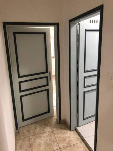 two doors in a room with a tile floor at Résidence Dibéla Haut de Guégué in Libreville
