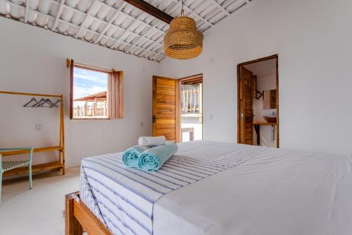 a bedroom with a large bed with blue towels on it at Casa na Praia Preá - Casa Inteira in Prea