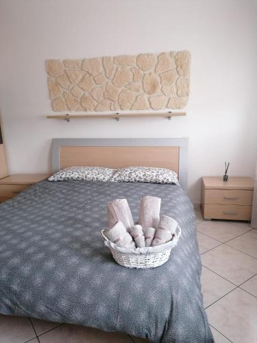 a basket of towels sitting on a bed at Il Piacere di Casa - Appartamento a Porto Viro in Porto Viro