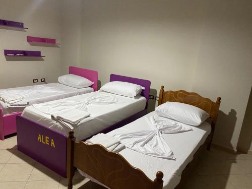 dwa łóżka w pokoju fioletowo-białym w obiekcie "Nako" apartment w Tiranie