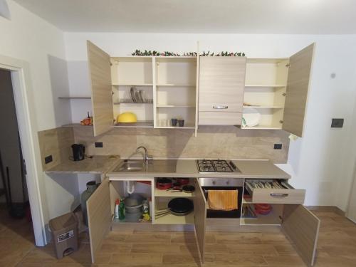 una pequeña cocina con armarios blancos y fregadero en Monolocale Palermo torretta, en Torretta