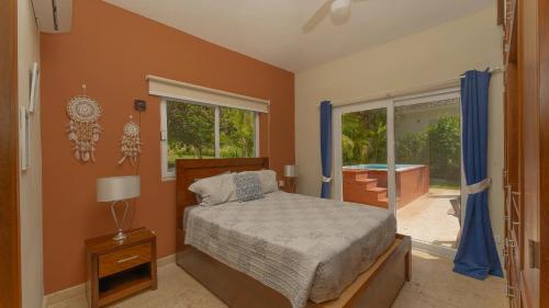 Schlafzimmer mit einem Bett, einem Fenster und einer Badewanne in der Unterkunft 2 Bed, 2 Bath, New Jacuzzi, High Speed Wi-Fi in Sosúa