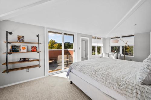 een witte slaapkamer met een bed en een groot raam bij 3390 Folsom St, Unit 206 in Boulder