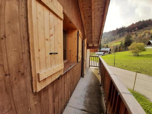 a wooden building with a door and a fence at 40m2 au pied des pistes Hauteluce les saisies 4 à 6 personnes in Hauteluce