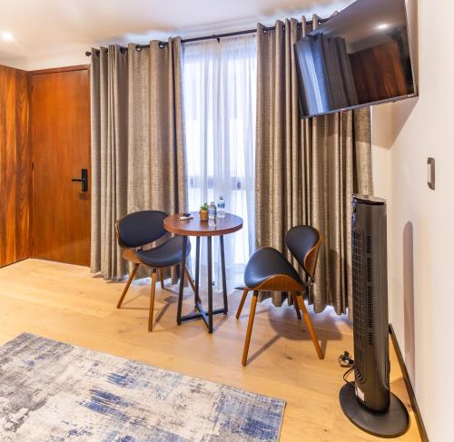 a living room with a table and chairs and a television at Casa Castillo in Mexico City