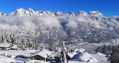 a snowy mountain with snow covered mountains in the background at Panorama Hak - CharmingStay in Flumserberg