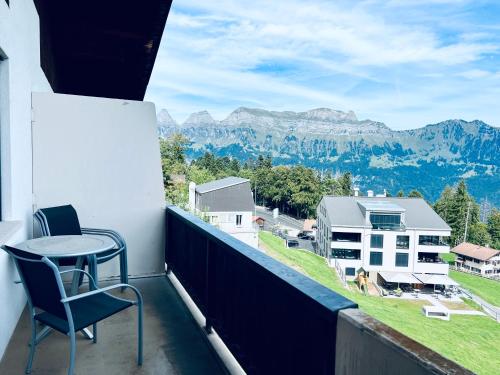 a balcony with a table and chairs and mountains at Panorama Hak - CharmingStay in Flumserberg
