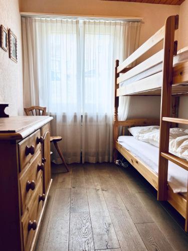 a bedroom with a bunk bed and a window at Panorama Hak - CharmingStay in Flumserberg