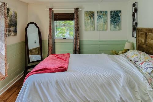 a bedroom with a large bed and a mirror at Boothbay Blue in Boothbay Harbor