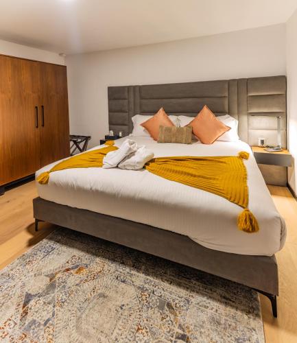 a bedroom with a large bed with a yellow blanket on it at Casa Castillo in Mexico City