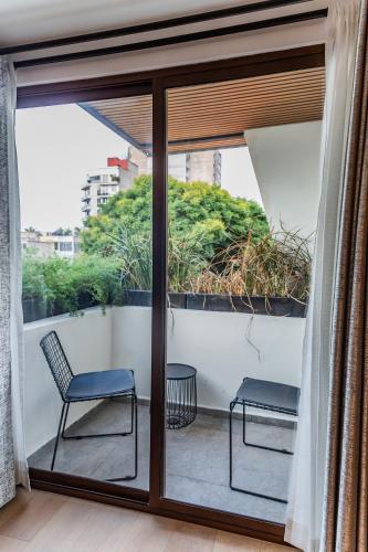 a balcony with two chairs and sliding glass doors at Casa Castillo in Mexico City