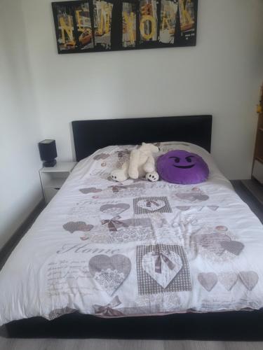 a dog laying on a bed with a blanket at chambre chez Mj in Sainte-Eulalie