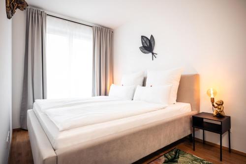 德勒斯登的住宿－NK Apartments - Hafencity Dresden mit Elbblick - Modern & Zentral，卧室配有一张大白色床和窗户