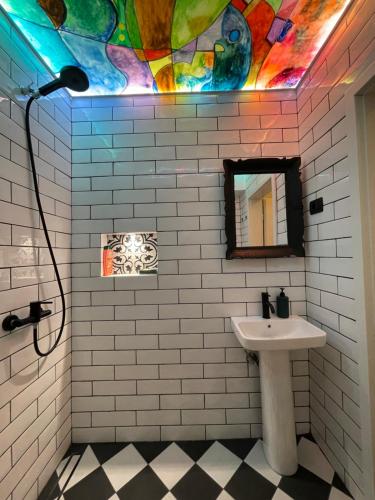 ein Badezimmer mit Waschbecken und Spiegel in der Unterkunft Vintage Apartment in Pristina