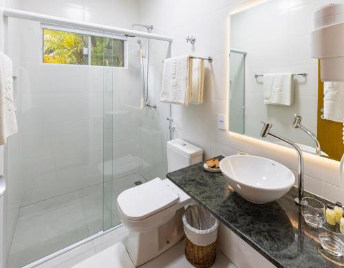 a bathroom with a toilet and a glass shower at Itamambuca Eco Resort in Ubatuba