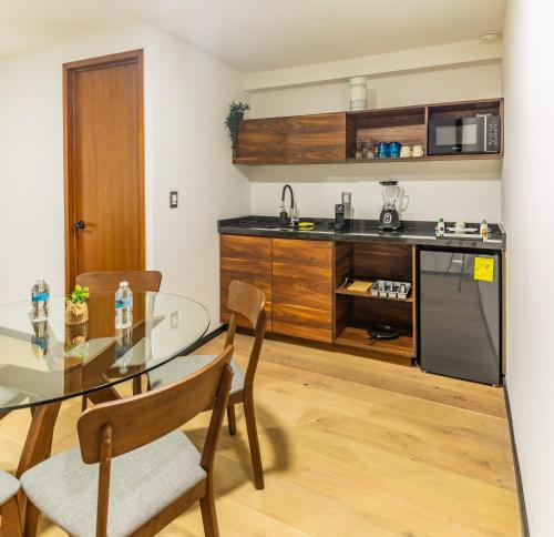 a kitchen with a glass table with chairs and a counter at Casa Castillo in Mexico City