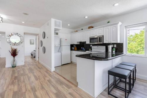 a kitchen with white cabinets and a counter top at Seaside Escape Steps to Beach, Dining, Shopping and Las Olas! in Fort Lauderdale