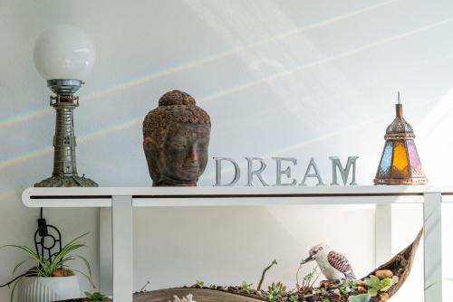 a shelf with a statue and a dream sign on it at Beachside Escape - 100m from the beach in Kiama