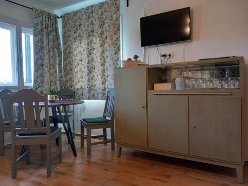 a living room with a television on top of a cabinet at Bükki csend vendégház in Bükkszentkereszt