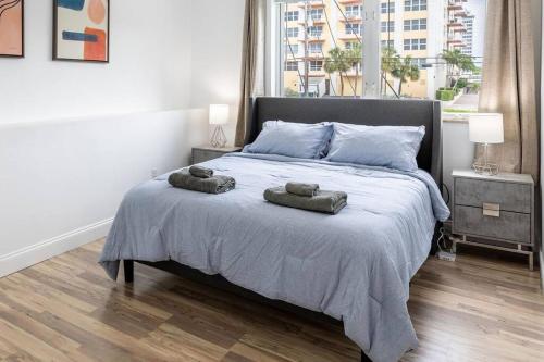 a bedroom with a bed with two towels on it at Seaside Escape Steps to Beach, Dining, Shopping and Las Olas! in Fort Lauderdale