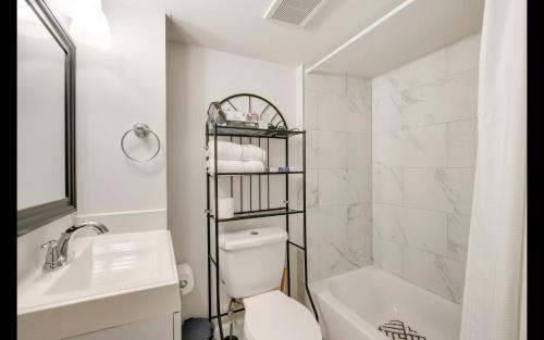 a white bathroom with a toilet and a sink at Splendid Cheerful 2-bedroom residential in Hyattsville