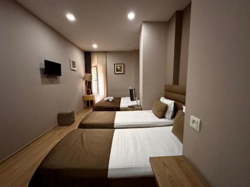a hotel room with two beds and a television at Terrace Tbilisi Center in Tbilisi City