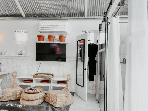 a white room with a tv and a table and chairs at Inn Santa Clara in Santa Clara
