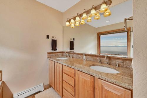 La salle de bains est pourvue de 2 lavabos et d'un grand miroir. dans l'établissement Kenai Vacation Rental with Volcano and Glacier Views!, à Kenai