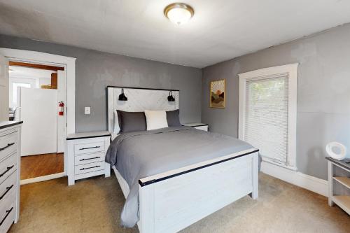a bedroom with a white bed and a refrigerator at Vermont Marble Haven - Unit 2 in Rutland