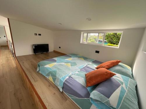 ein großes Bett in einem Zimmer mit Fenster in der Unterkunft Tiny House Tauramena in Tauramena