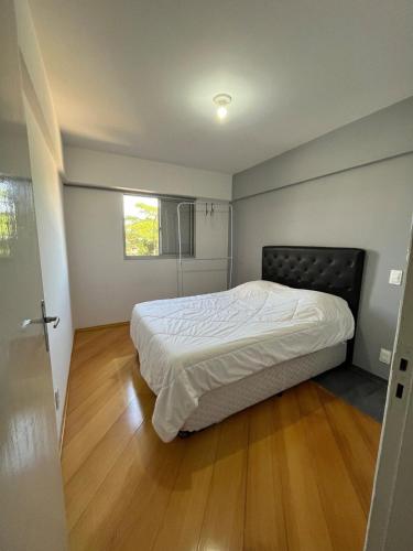 a bedroom with a bed and a wooden floor at Apartamento próximo ao metro Jabaquara, apto 13 in São Paulo