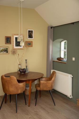 a dining room with a wooden table and chairs at The Cat and The Owl B&B in Groenlo