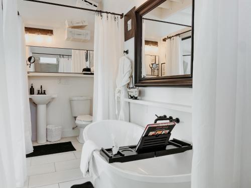 a bathroom with a white tub and a sink at Inn Santa Clara in Santa Clara