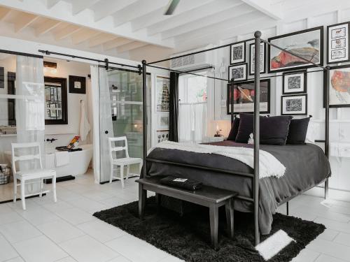 a bedroom with a canopy bed and a bathroom at Inn Santa Clara in Santa Clara