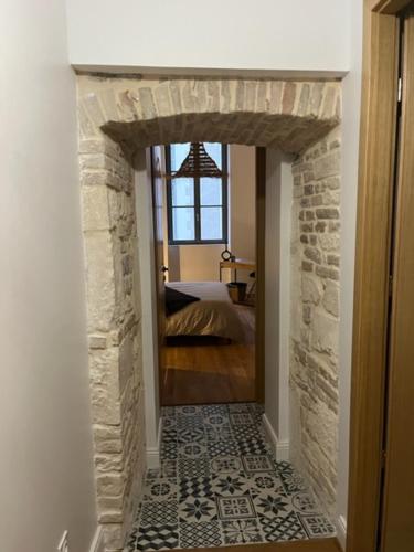 a hallway with a stone fireplace with a bed in a bedroom at centre ville Chalon sur Saône in Chalon-sur-Saône