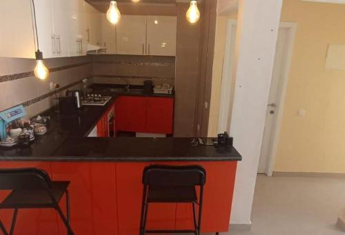 een keuken met rode kasten en een zwart aanrecht bij T20 in Safi
