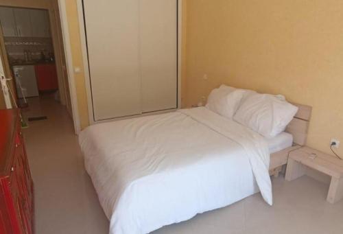 een slaapkamer met een wit bed en een grote spiegel bij T20 in Safi