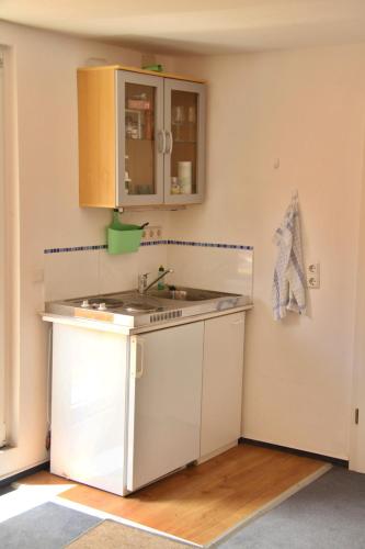 a small kitchen with a sink and a counter at Freundliches Appartement - Bitte Angaben zum Gastgeber lesen in Wehrheim