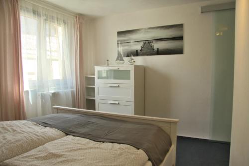 a bedroom with a bed and a dresser at Freundliches Appartement - Bitte Angaben zum Gastgeber lesen in Wehrheim