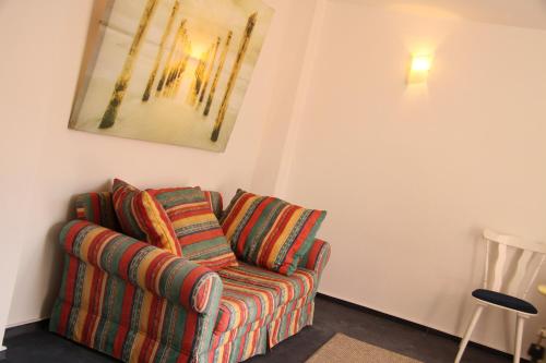 una sala de estar con sofá y una pintura en la pared en Freundliches Appartement - Bitte Angaben zum Gastgeber lesen, en Wehrheim