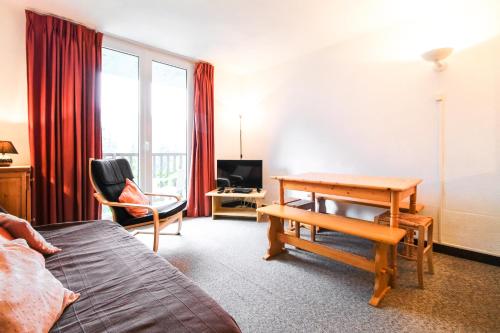 a hotel room with a bed and a desk and a table at Spacious Apartment Iris, Flaine Foret in Flaine