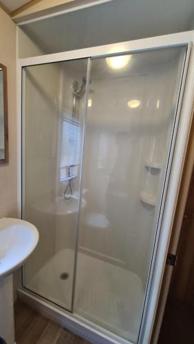 a shower with a glass door in a bathroom at 8 Berth Luxury Caravan Butlins Holiday Village Skegness in Skegness