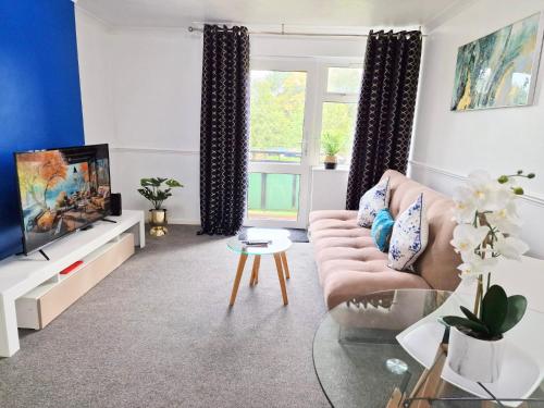 ein Wohnzimmer mit einem Sofa und einem TV in der Unterkunft 1 Bed Central Serviced Accommodation with Balcony in Stevenage Free WIFI by Stay Local Home Welcome Contractors Business Travellers Families in Stevenage